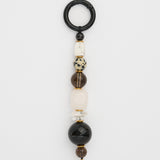 Beaded gemstone keychain with black, white, and brown beads on a white background